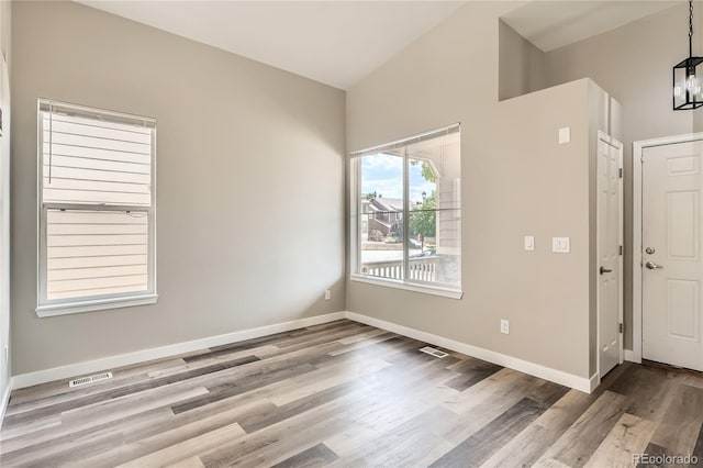 10626 Cherrybrook Cir, Highlands Ranch, CO 80126 - unfurnished room featuring wood finished floors, lofted ceiling, and a chandelier