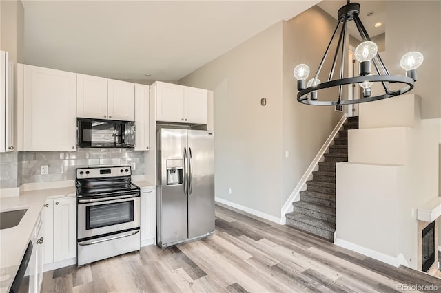 10626 Cherrybrook Cir, Highlands Ranch, CO 80126 - kitchen with appliances with stainless steel finishes, a chandelier, light wood-style floors, backsplash, and white cabinetry