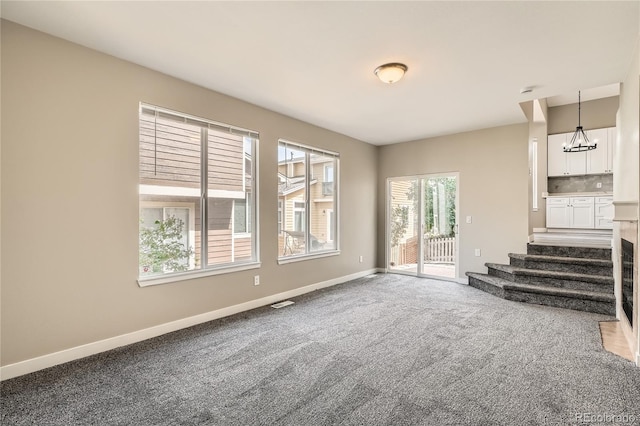10626 Cherrybrook Cir, Highlands Ranch, CO 80126 - unfurnished living room with a chandelier, carpet, and stairway