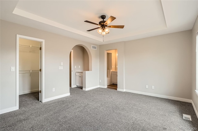10626 Cherrybrook Cir, Highlands Ranch, CO 80126 - unfurnished bedroom with a raised ceiling, arched walkways, a spacious closet, and carpet