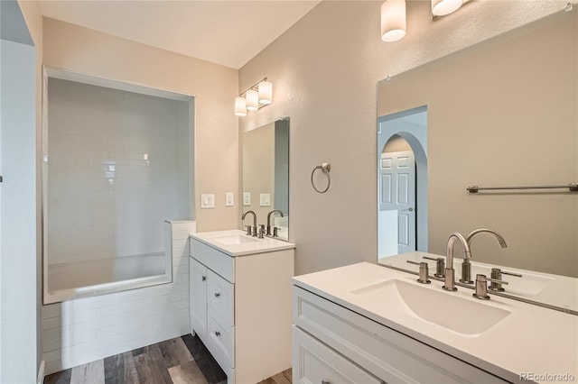 10626 Cherrybrook Cir, Highlands Ranch, CO 80126 - bathroom featuring two vanities, wood finished floors, and tiled shower / bath combo