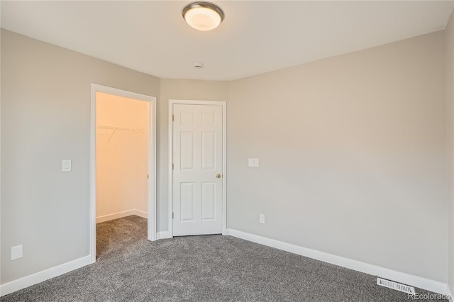 10626 Cherrybrook Cir, Highlands Ranch, CO 80126 - unfurnished bedroom featuring a spacious closet, dark carpet, and a closet