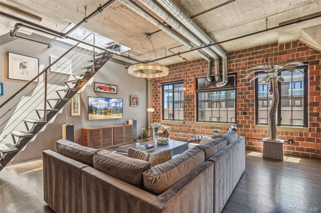 1863 Wazee St Unit 6B, Denver, CO 80202 - living room featuring hardwood / wood-style floors, brick wall, stairs, and a chandelier