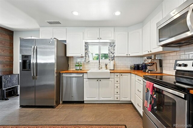 4315 S Elati St, Englewood, CO 80110 - kitchen with stainless steel appliances, white cabinets, wood counters, and recessed lighting