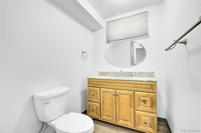 641 E 104th Pl, Northglenn, CO 80233 - half bathroom featuring vanity, toilet, and wood finished floors