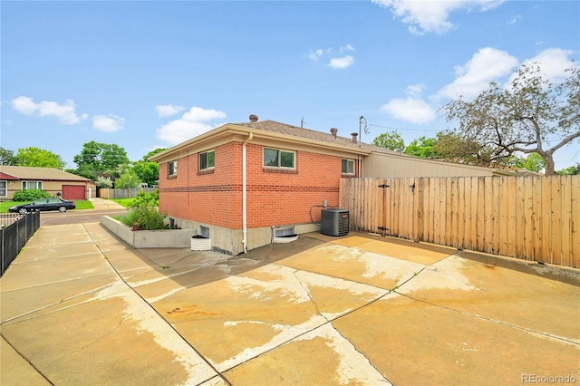 641 E 104th Pl, Northglenn, CO 80233 - rear view of property with central AC, brick siding, and a patio area