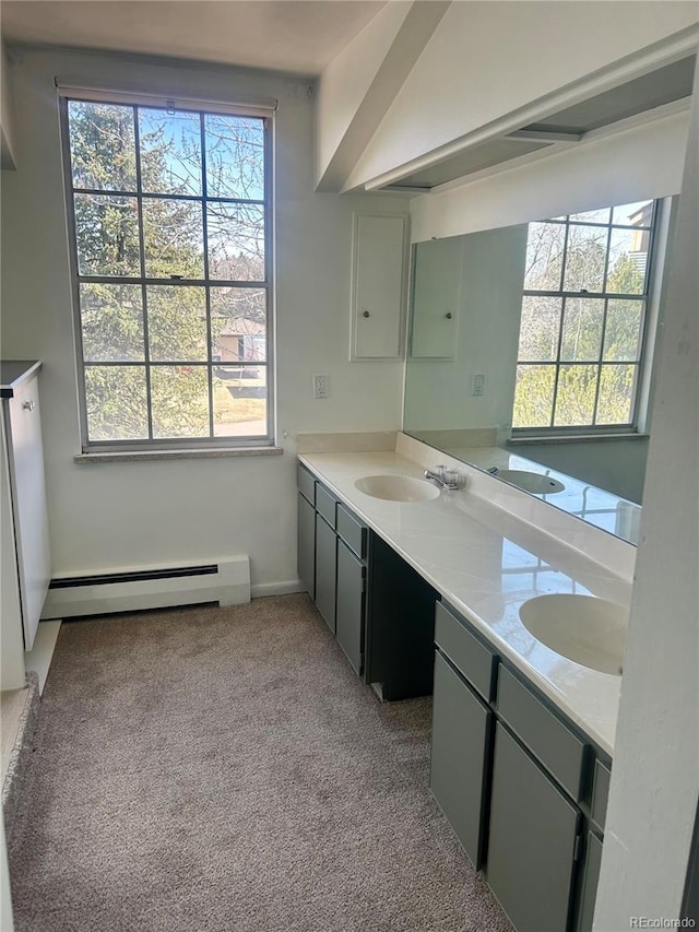 bathroom featuring double vanity, carpet flooring, a baseboard radiator, and a sink