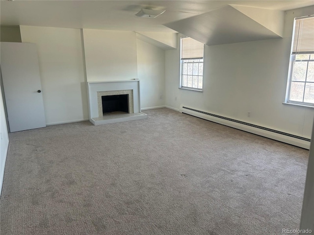 unfurnished living room with a healthy amount of sunlight, a fireplace with raised hearth, carpet, and a baseboard radiator