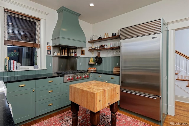747 N Downing St, Denver, CO 80218 - kitchen featuring stainless steel appliances, green cabinets, custom exhaust hood, wood finished floors, and open shelves