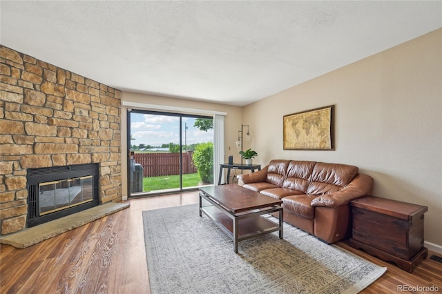 7474 E Arkansas Ave Unit 13-02, Denver, CO 80231 - living area featuring wood finished floors and a stone fireplace