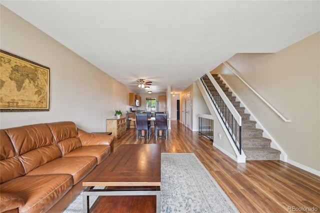 7474 E Arkansas Ave Unit 13-02, Denver, CO 80231 - living room featuring stairway, wood finished floors, a ceiling fan, and baseboards