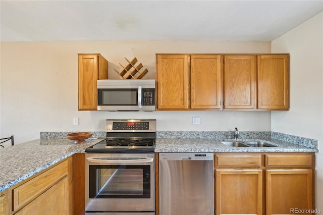 7474 E Arkansas Ave Unit 13-02, Denver, CO 80231 - kitchen with appliances with stainless steel finishes, a sink, light stone countertops, and brown cabinetry
