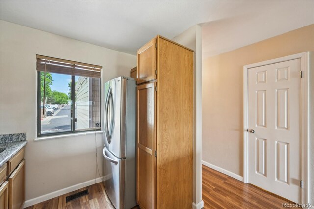 7474 E Arkansas Ave Unit 13-02, Denver, CO 80231 - kitchen with freestanding refrigerator, baseboards, and wood finished floors