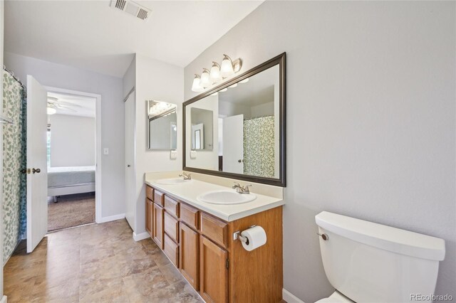 7474 E Arkansas Ave Unit 13-02, Denver, CO 80231 - bathroom with toilet, double vanity, a ceiling fan, and baseboards