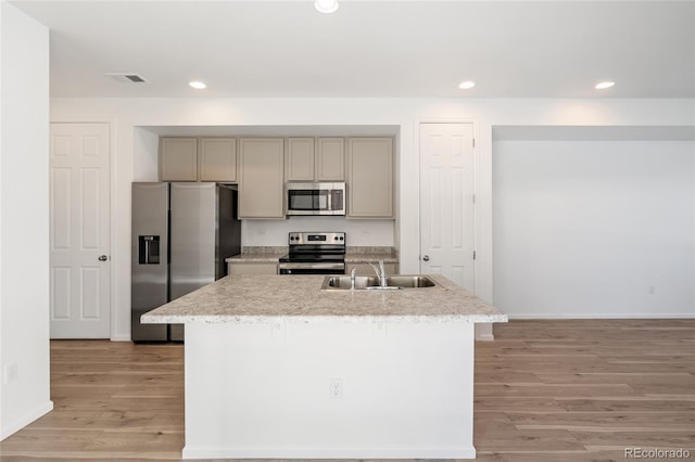 kitchen featuring gray cabinetry, light wood-type flooring, recessed lighting, stainless steel appliances, and a sink