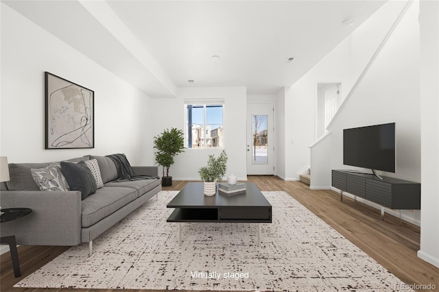 living room with stairs, wood finished floors, and baseboards