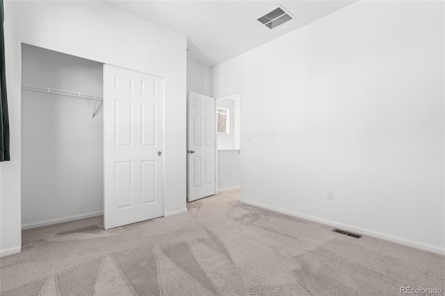 unfurnished bedroom with carpet flooring, baseboards, visible vents, and a closet