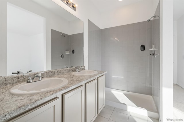 full bath with a sink, double vanity, tile patterned flooring, and a tile shower