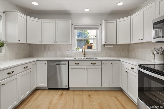 4567 Grove St, Denver, CO 80211 - kitchen featuring appliances with stainless steel finishes, a sink, white cabinetry, recessed lighting, and light wood-style floors