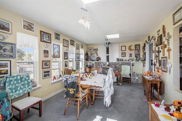 222 S Logan St, Grover, CO 80729 - carpeted dining space featuring a skylight, a wood stove, and a chandelier