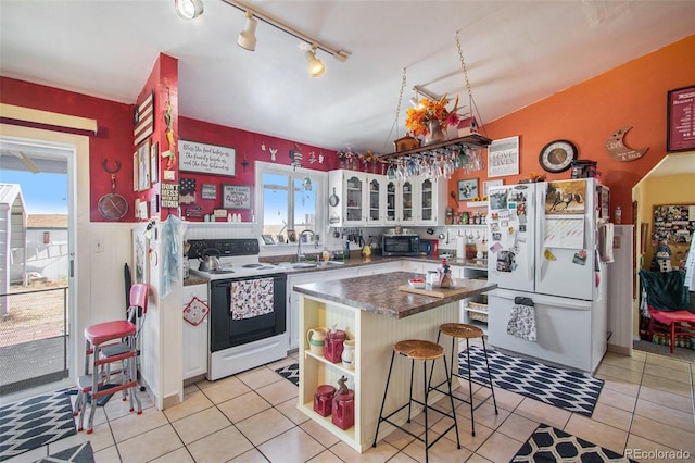 222 S Logan St, Grover, CO 80729 - kitchen with white appliances, open shelves, a breakfast bar, a kitchen island, and light tile patterned flooring