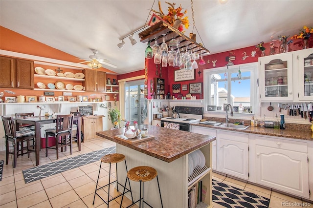 222 S Logan St, Grover, CO 80729 - kitchen featuring light tile patterned floors, vaulted ceiling, range with electric stovetop, and healthy amount of natural light