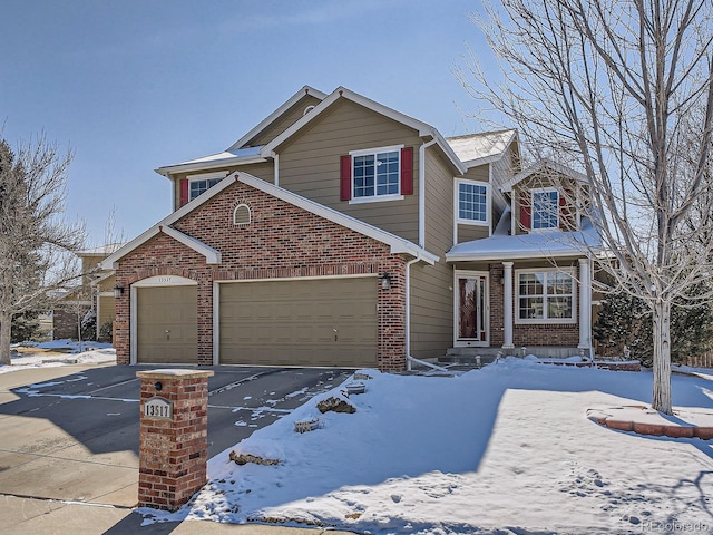 view of front of home featuring driveway, brick siding, and an attached garage