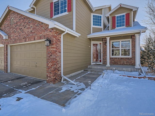 view of front of property with a garage, brick siding, and driveway