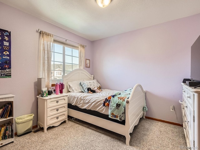 bedroom featuring light carpet, a textured ceiling, and baseboards