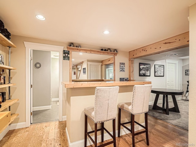 bar with recessed lighting, baseboards, a dry bar, and wood finished floors