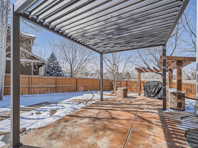 snow covered patio featuring a fenced backyard, a grill, and a pergola