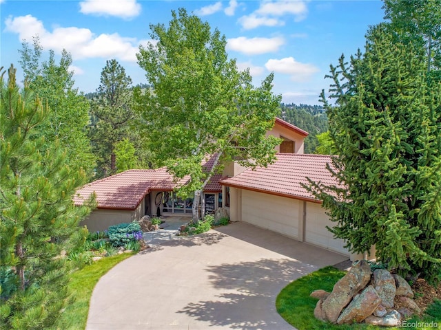 2398 Bitterroot Ln, Golden, CO 80401 - view of front of home with a tile roof, driveway, stucco siding, and an attached garage