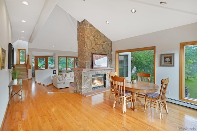 2398 Bitterroot Ln, Golden, CO 80401 - dining area with light wood finished floors, a stone fireplace, high vaulted ceiling, and recessed lighting