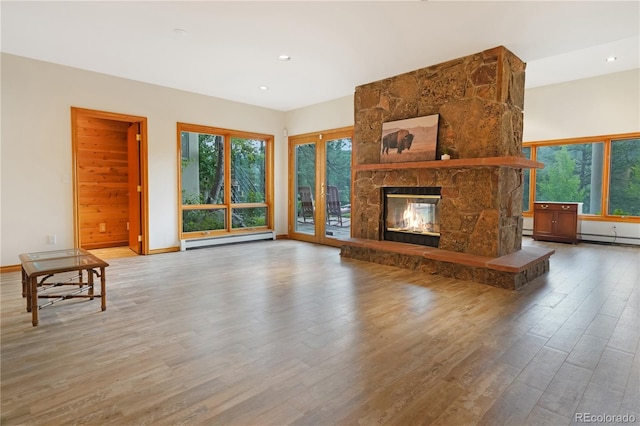 2398 Bitterroot Ln, Golden, CO 80401 - unfurnished living room featuring a baseboard radiator, wood finished floors, healthy amount of natural light, a fireplace, and recessed lighting