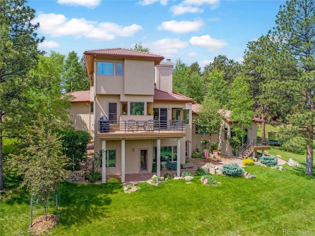 2398 Bitterroot Ln, Golden, CO 80401 - back of house featuring stucco siding, a chimney, a tile roof, and a yard