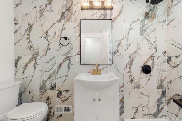 bathroom with walk in shower, vanity, toilet, and tile walls