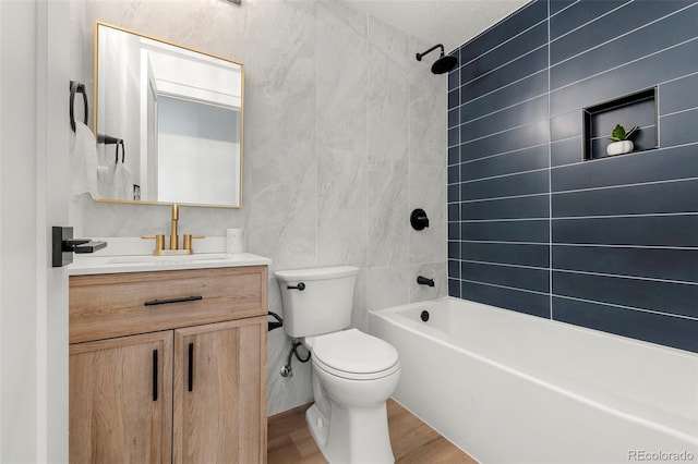 full bathroom with wood-type flooring, toilet, a textured ceiling, tiled shower / bath combo, and vanity