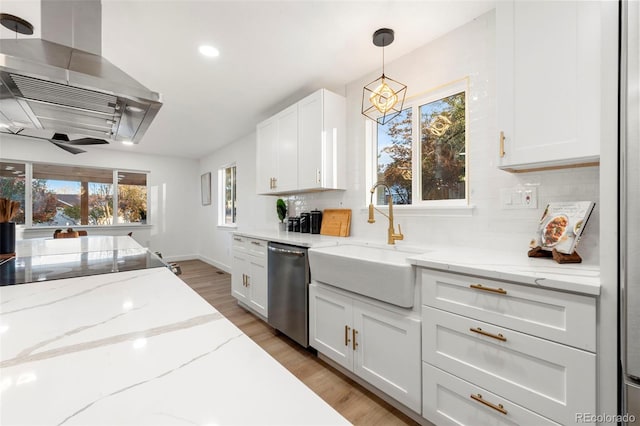 kitchen featuring stainless steel dishwasher, plenty of natural light, island range hood, and decorative light fixtures