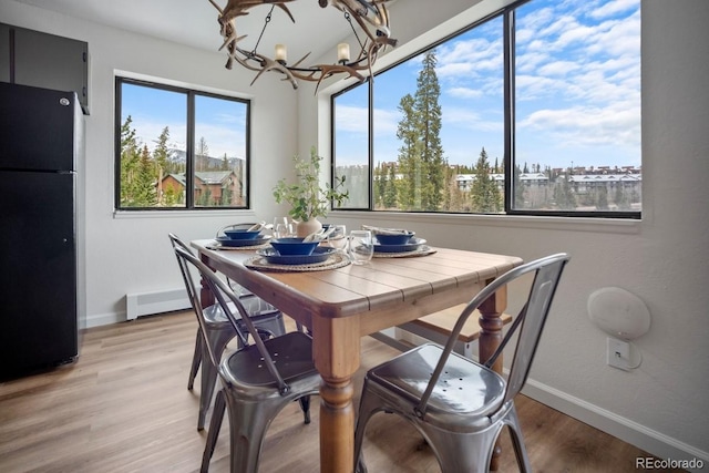 9876 Ryan Gulch Rd Unit F-206, Silverthorne, CO 80498 - dining room featuring plenty of natural light, a chandelier, and baseboards