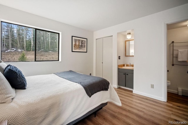 9876 Ryan Gulch Rd Unit F-206, Silverthorne, CO 80498 - bedroom with wood finished floors, a sink, baseboards, ensuite bathroom, and a closet