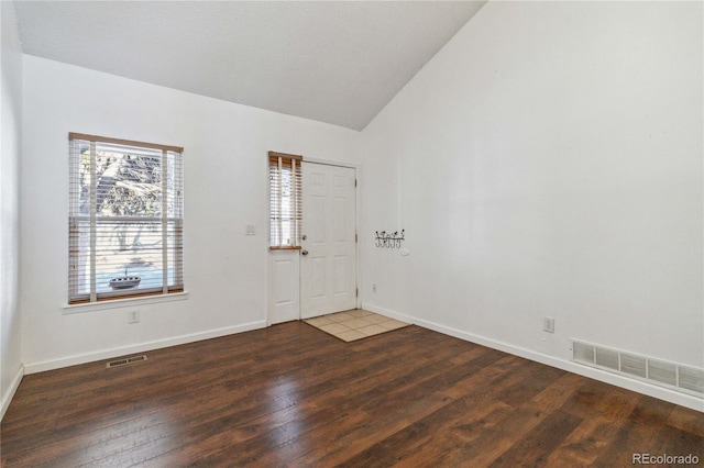 foyer featuring vaulted ceiling and dark wood-type flooring