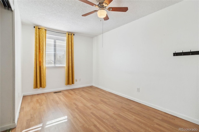 unfurnished room with ceiling fan, light hardwood / wood-style floors, and a textured ceiling