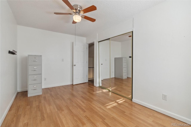 unfurnished bedroom with light hardwood / wood-style floors, a textured ceiling, and ceiling fan