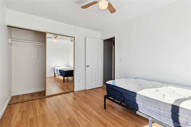 bedroom with a closet, ceiling fan, and light hardwood / wood-style flooring