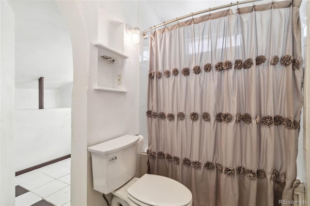 bathroom featuring tile patterned floors, toilet, and walk in shower