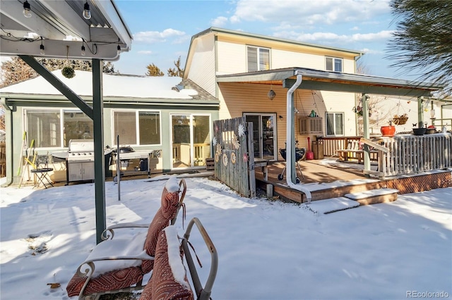 snow covered back of property featuring a wooden deck