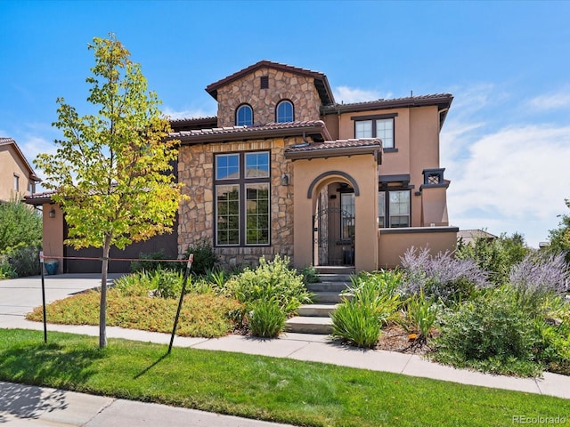 2256 S Isabell Ct, Lakewood, CO 80228 - mediterranean / spanish house with stone siding, a tiled roof, and stucco siding