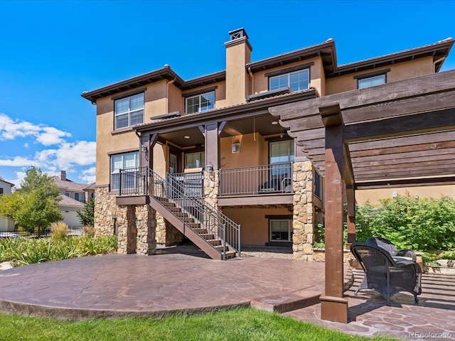 2256 S Isabell Ct, Lakewood, CO 80228 - rear view of property featuring stucco siding, stairs, a patio, and a chimney