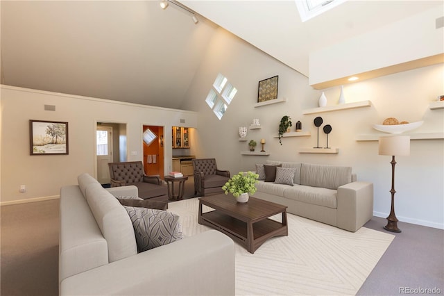 living room featuring carpet floors, a skylight, high vaulted ceiling, and track lighting