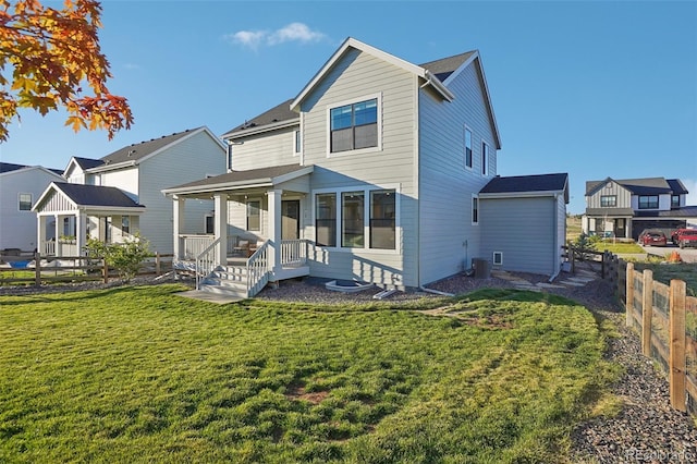 back of property featuring covered porch, central air condition unit, and a lawn